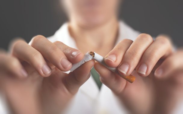 Persona rompiendo un cigarro para mostrar los efectos del tabaco